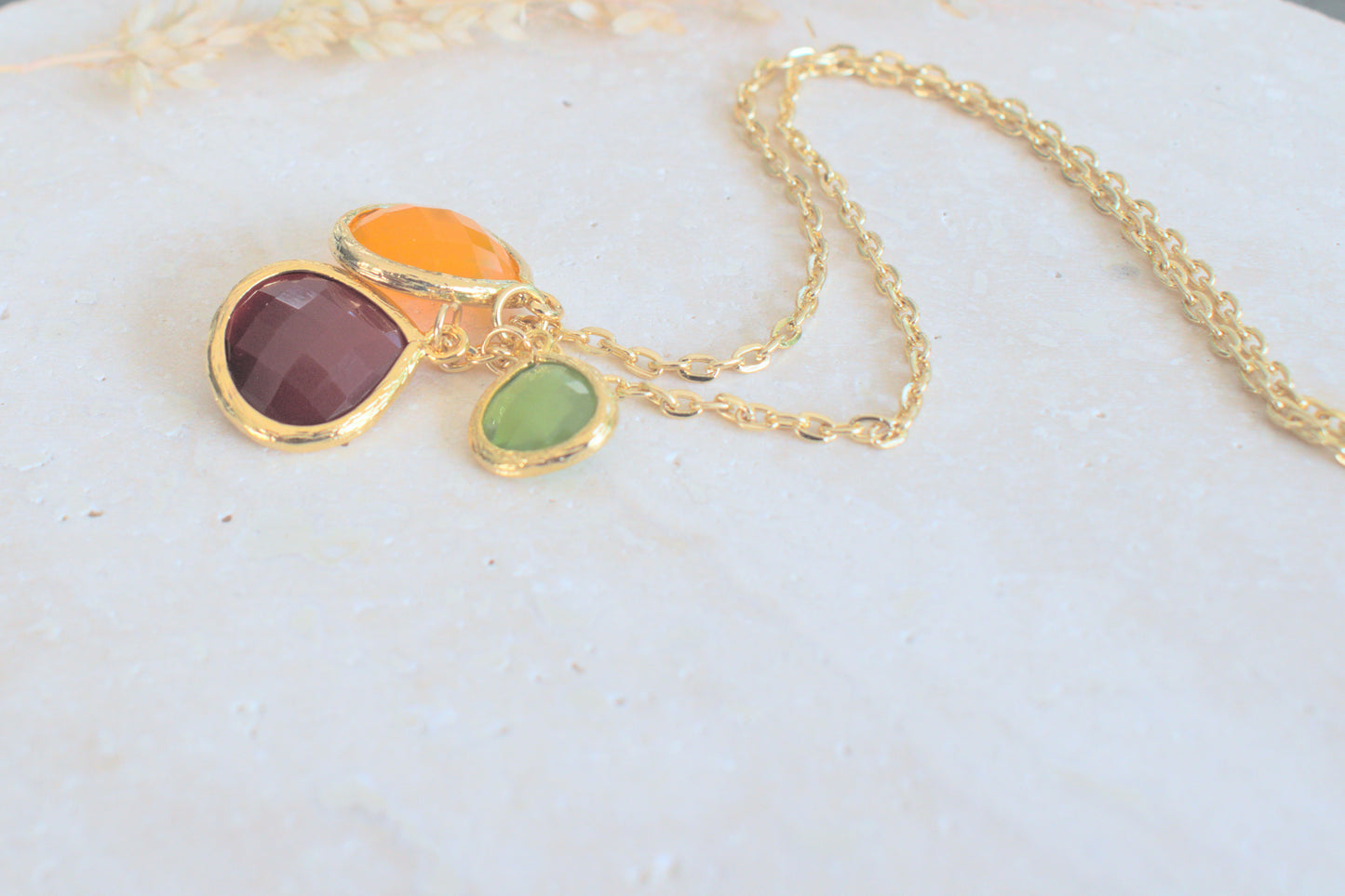 Goldene Kette mit bunten Steinen in verschiedenen Längen grün, orange und schwedenrot