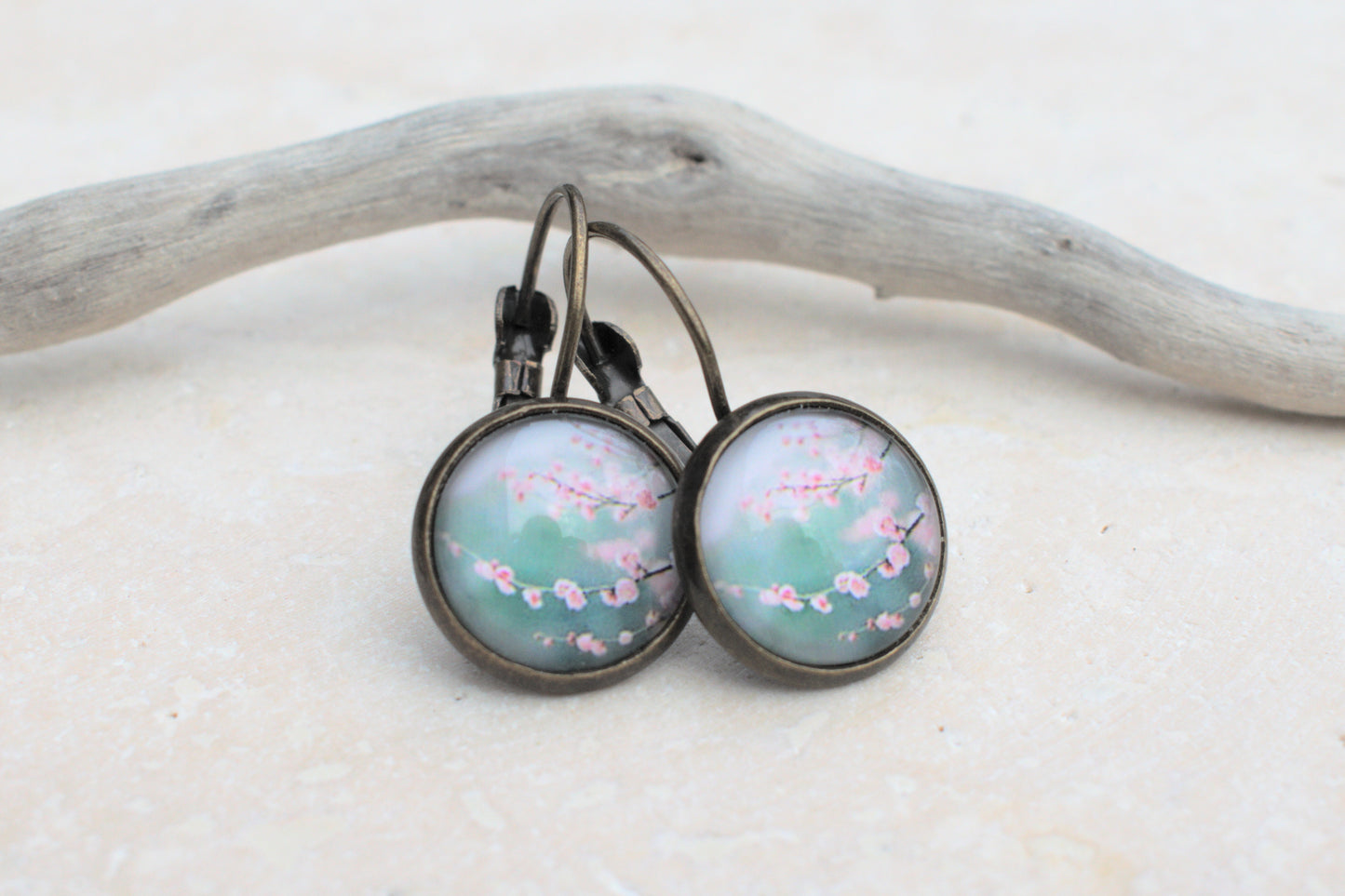 Bronzene Ohrringe mit Cabochon und Bild in blau und türkis mit rosa Kirschblüten