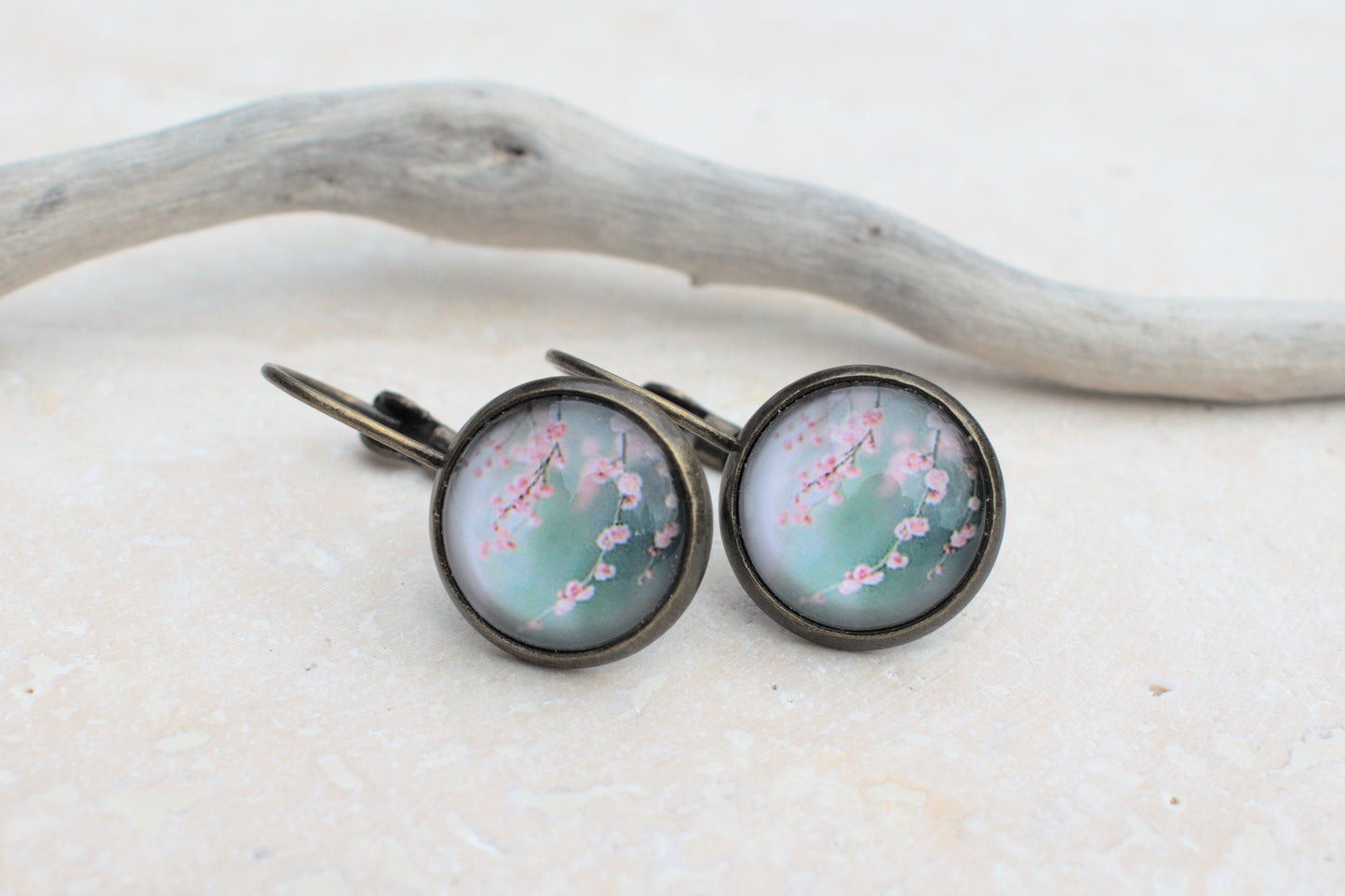 Bronzene Ohrringe mit Cabochon und Bild in blau und türkis mit rosa Kirschblüten