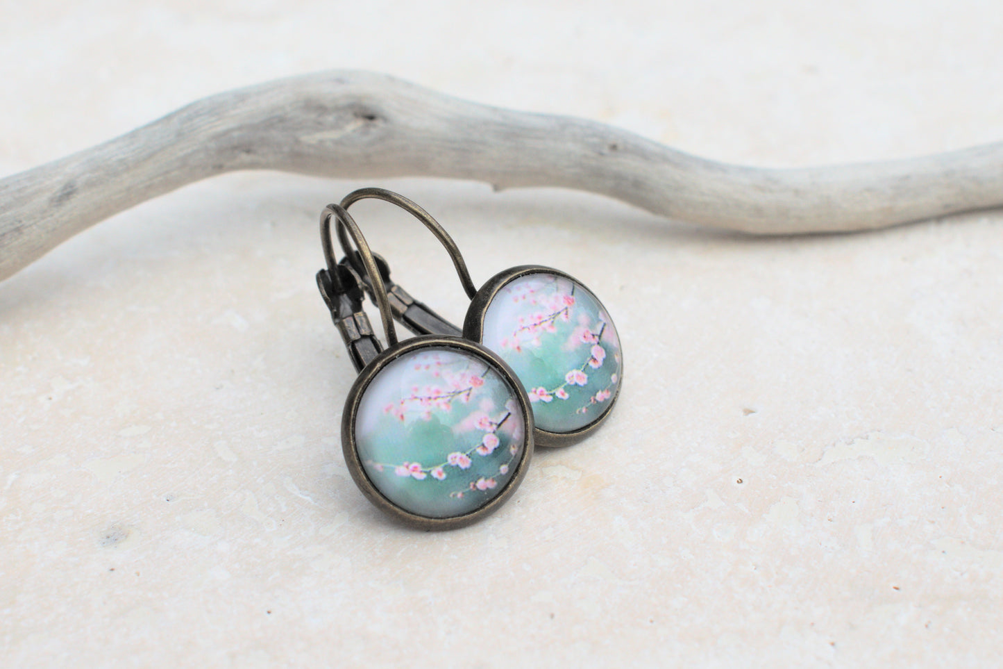Bronzene Ohrringe mit Cabochon und Bild in blau und türkis mit rosa Kirschblüten